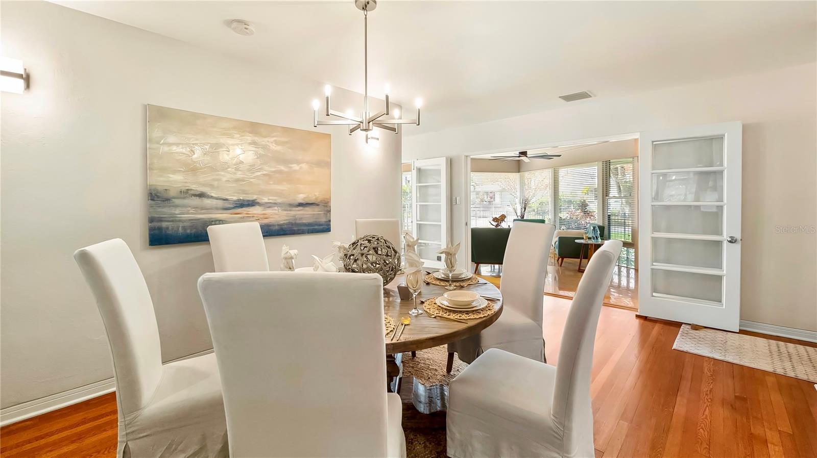 Sun-drenched dining room with beautiful hardwood floors. A perfect space for gatherings and creating lasting memories.