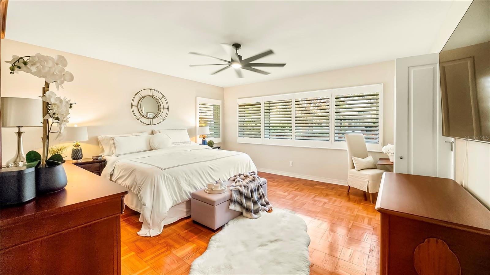 Spacious master bedroom with beautiful hardwood floors and a ceiling fan for added comfort.