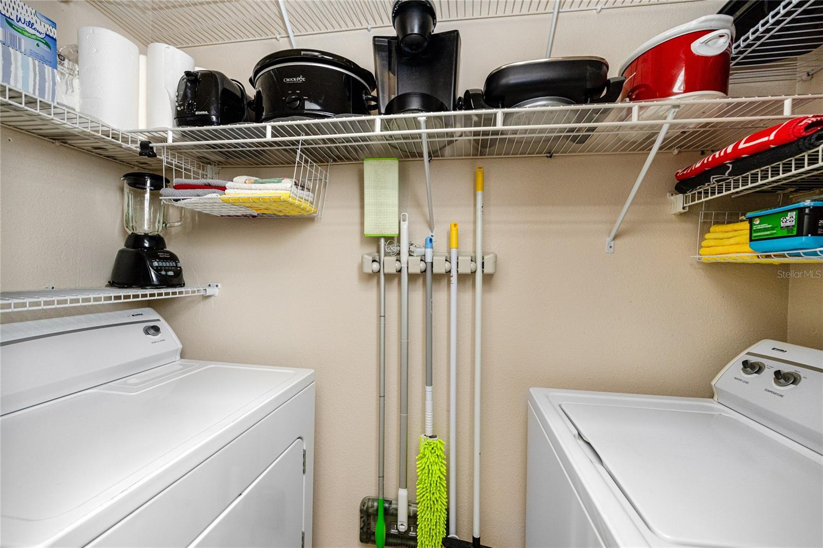 full sized washer and dryer off the kitchen with additional storage