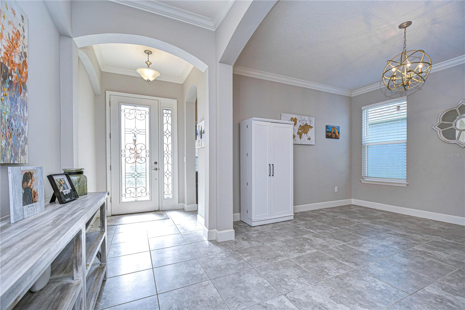 Grand foyer boasts crown molding, arched entryways, and plenty of natural light!