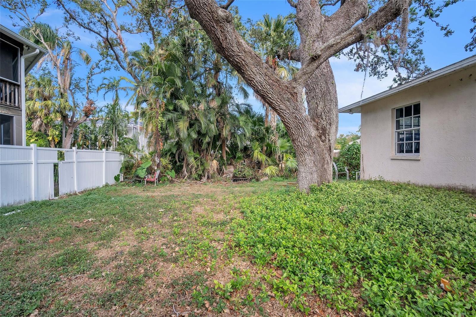 Spacious yard with mature trees.