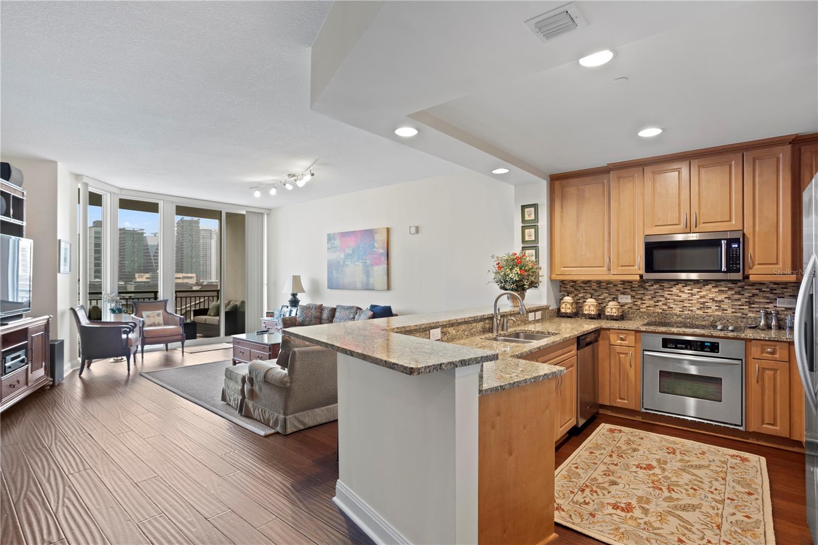 For those that enjoy cooking, there is loads of storage in the kitchen’s warm wood tone cabinetry adorned with complementing stone countertops and stainless-steel appliances.