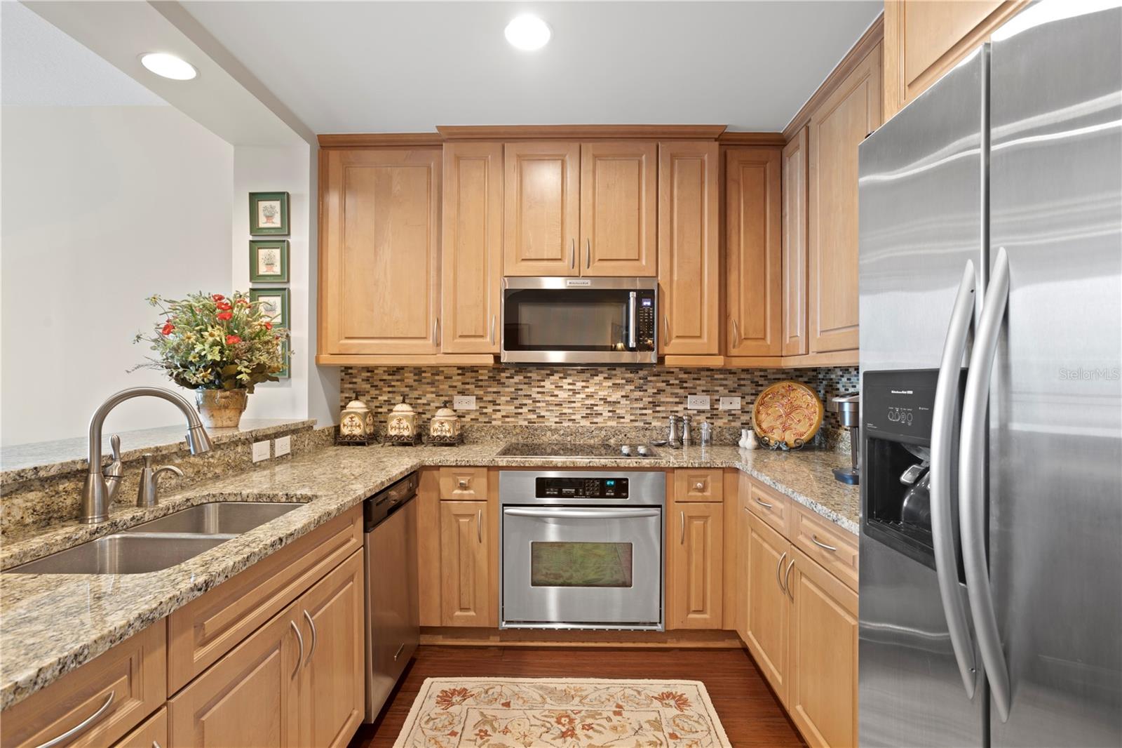 For those that enjoy cooking, there is loads of storage in the kitchen’s warm wood tone cabinetry adorned with complementing stone countertops and stainless-steel appliances.