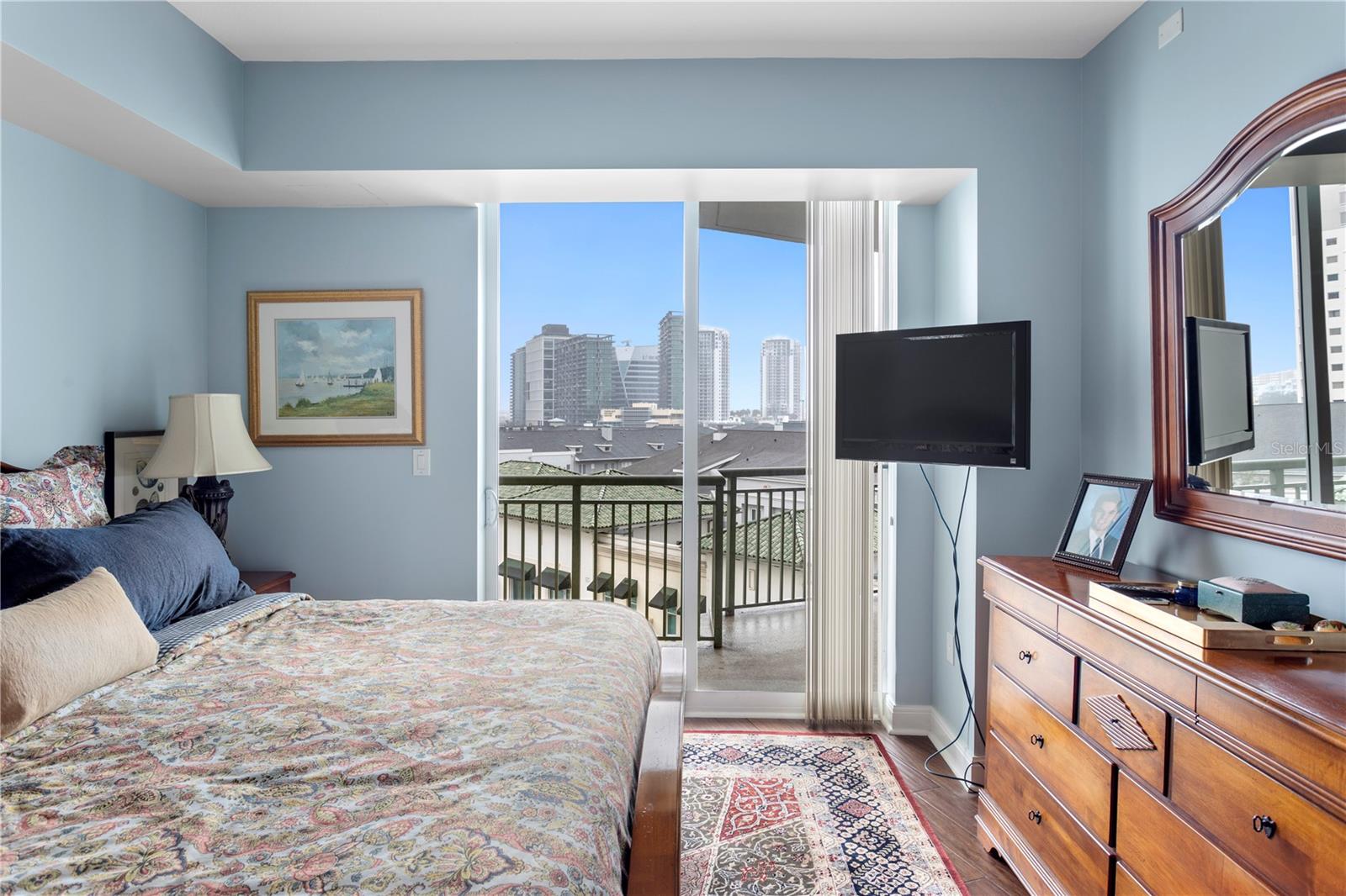 The primary bedroom is spacious with large sliding glass doors that lead to the wrap around balcony with views that extend to the gorgeous downtown skyline.