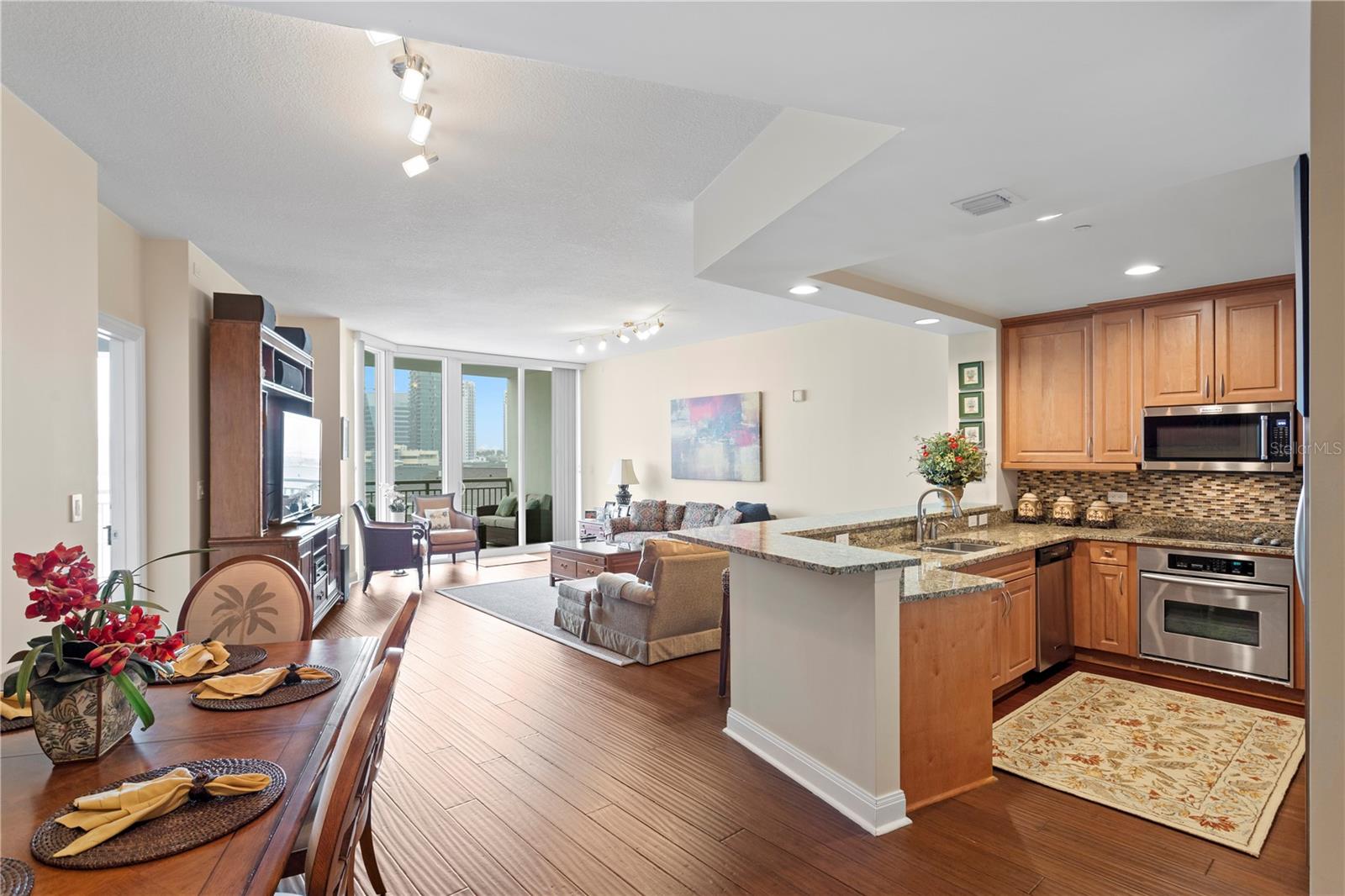 The open concept floorplan flows seamlessly from the entry hallway to the open kitchen and living and dining spaces.