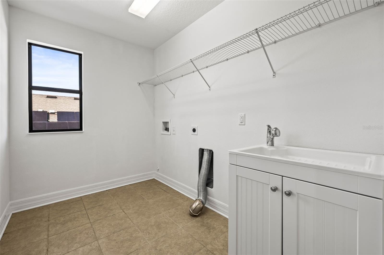 Laundry room with sink and above storage space.