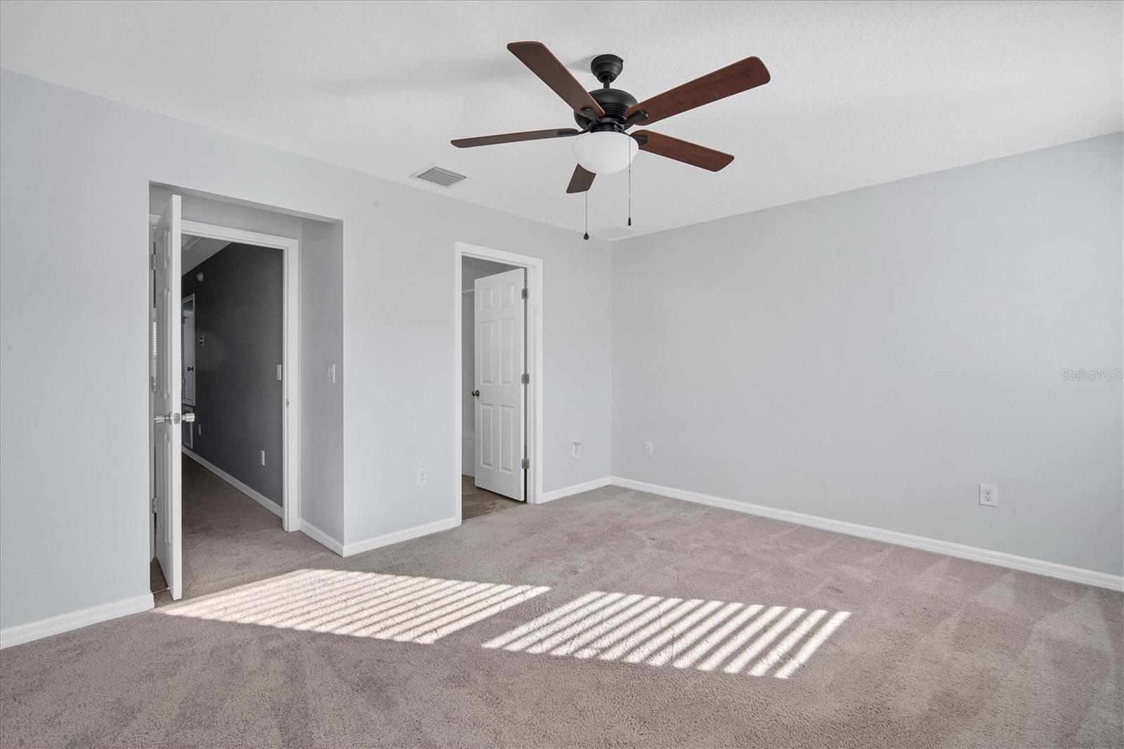 Spacious bathroom has decorative lighting and shelves, a roomy vanity with storage cabinets, a linen closet PLUS a huge walk-in closet