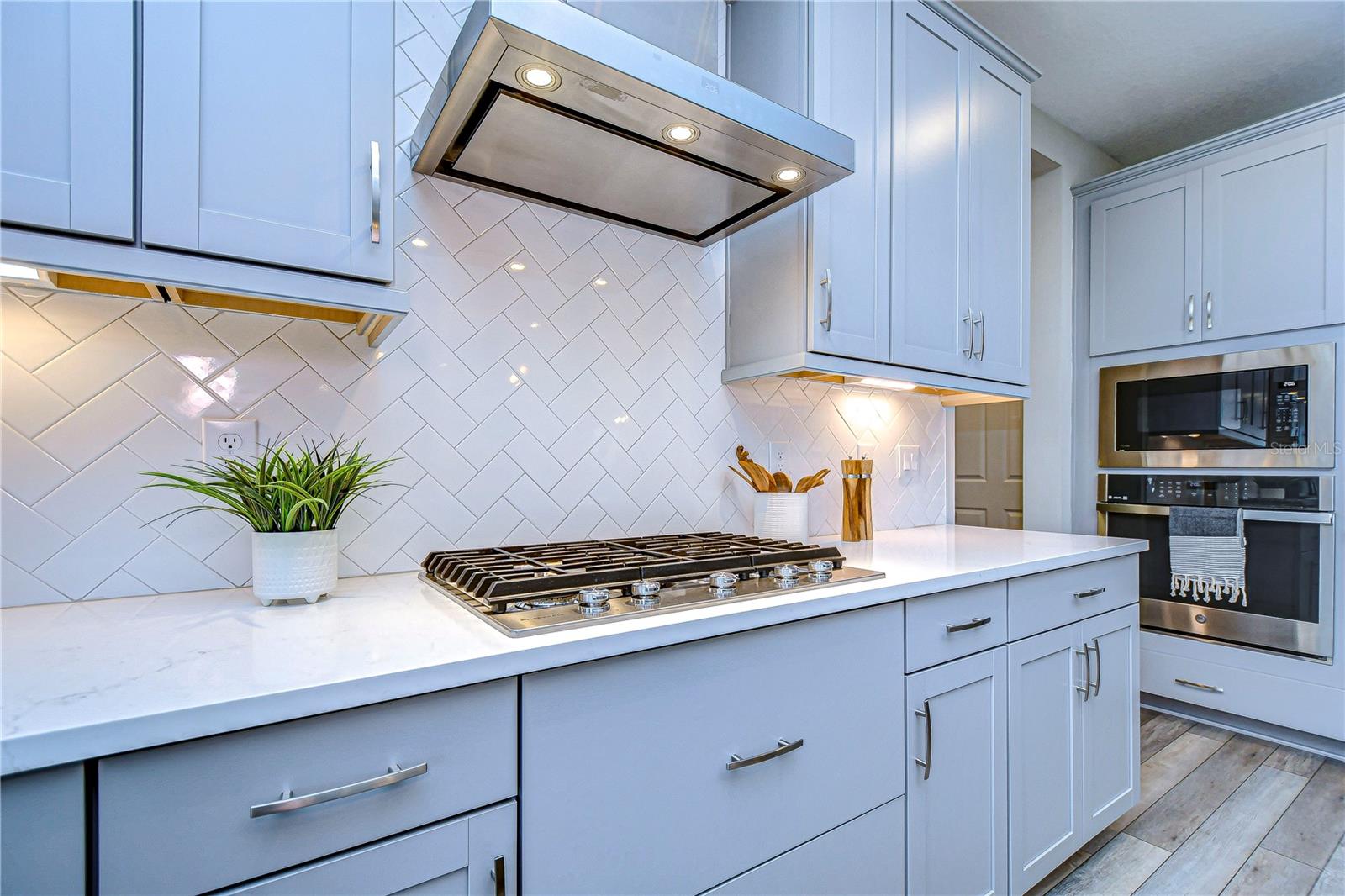 GORGEOUS gourmet kitchen features thoughtfully curated cabinets and tiled backsplash.