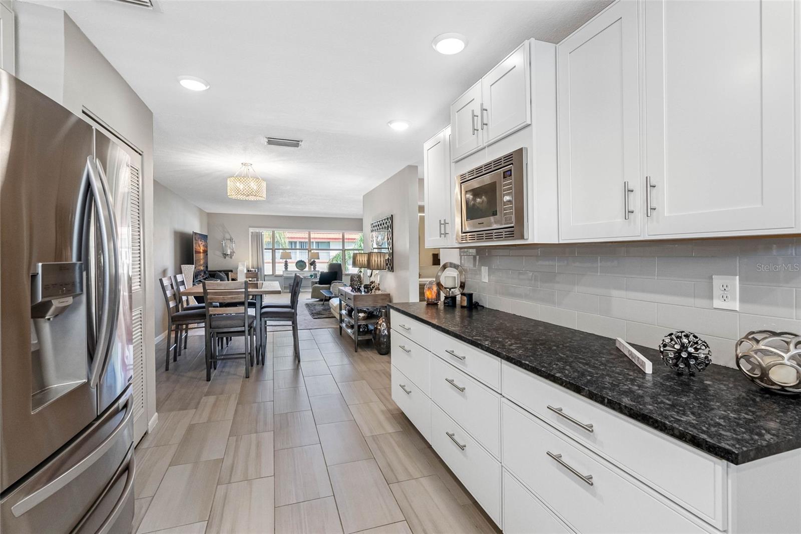 A remodeled kitchen with leathered granite countertops, stainless steel appliances, and a gas stove.