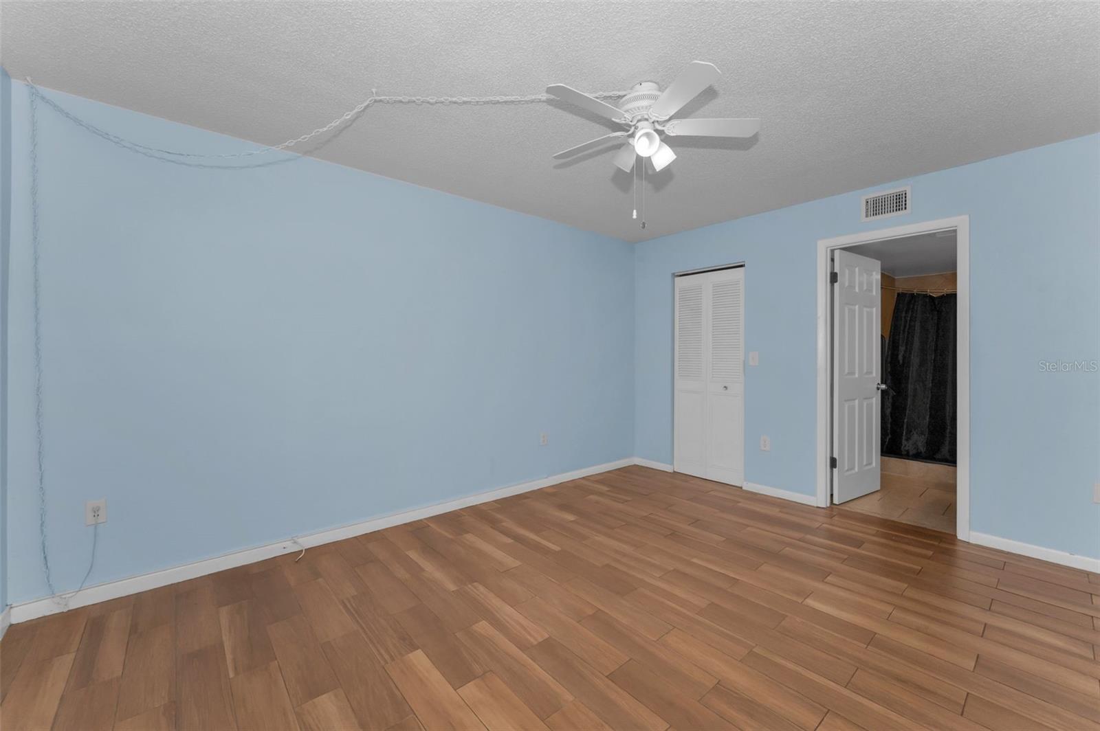 View of primary bedroom toward en-suite bathroom & walk-in closet