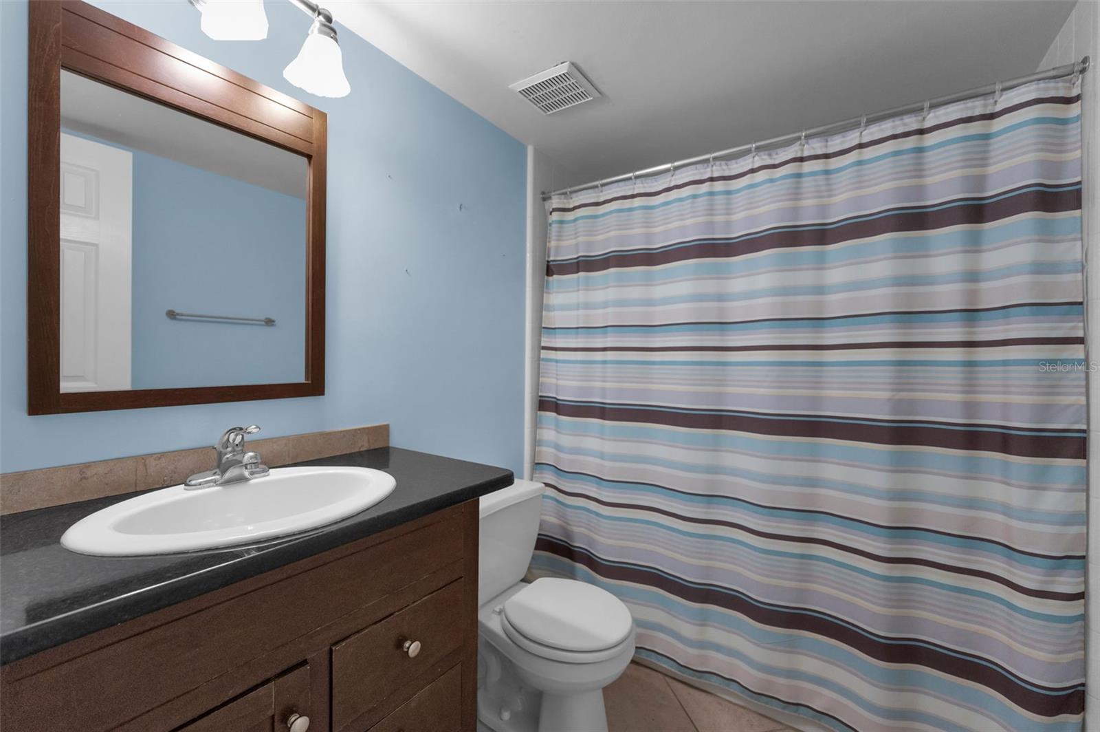 Guest bathroom with full bathtub & granite counters