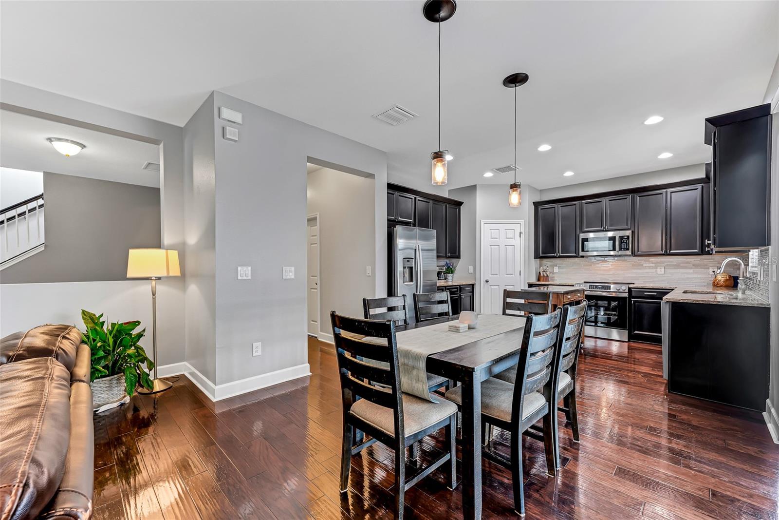 The hallway off the kitchen leads to a full bathroom, the 5th bedroom, and garage access, along with two additional storage areas, including a generous under-stair storage space.