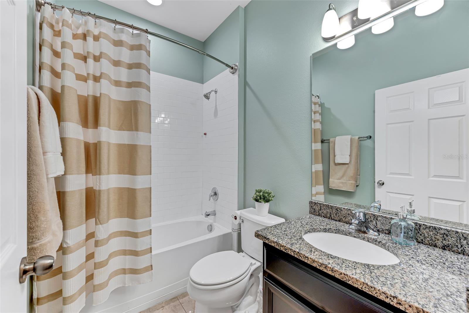 The first-floor full bathroom features granite countertops and a tub/shower combination, making it the perfect space for guests.