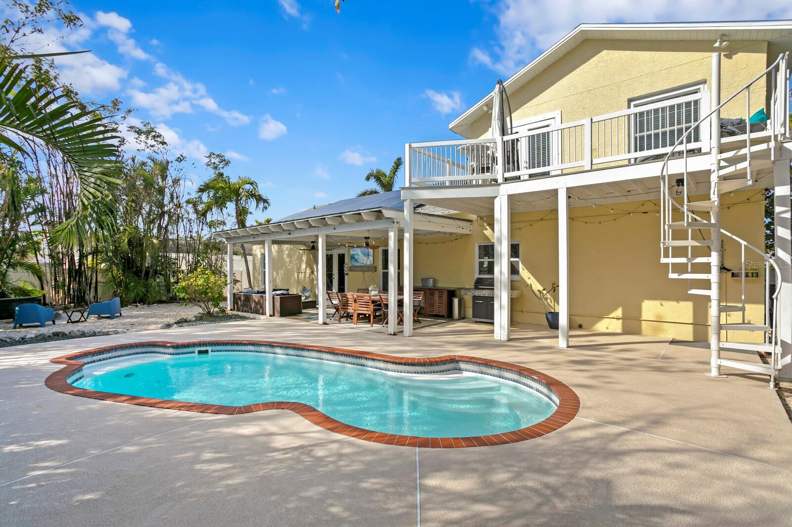 A spiral staircase leads you up from the pool deck to the primary suite balcony