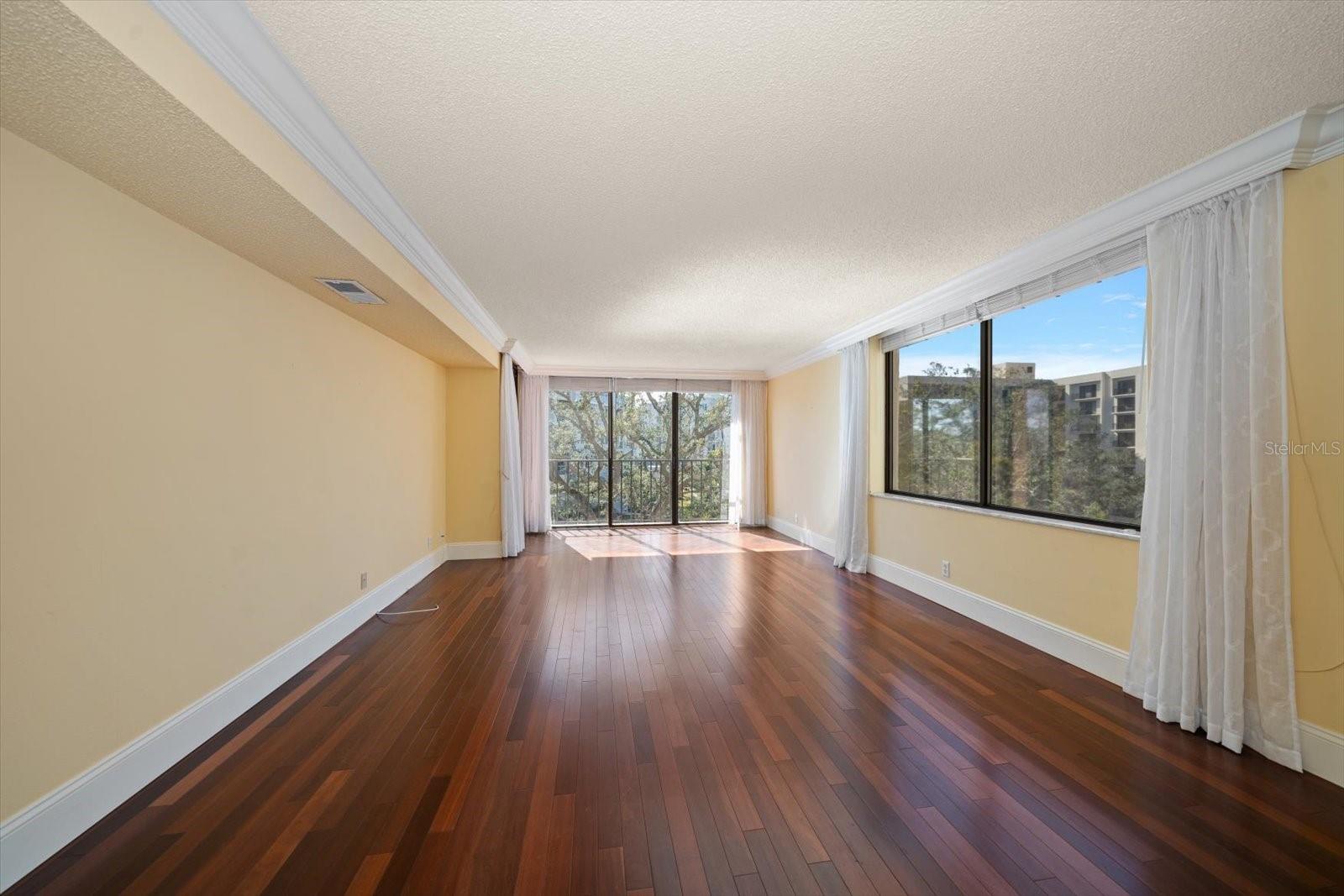 Light and bright living area richly appointed with cherry hardwood flooring and crown molding.