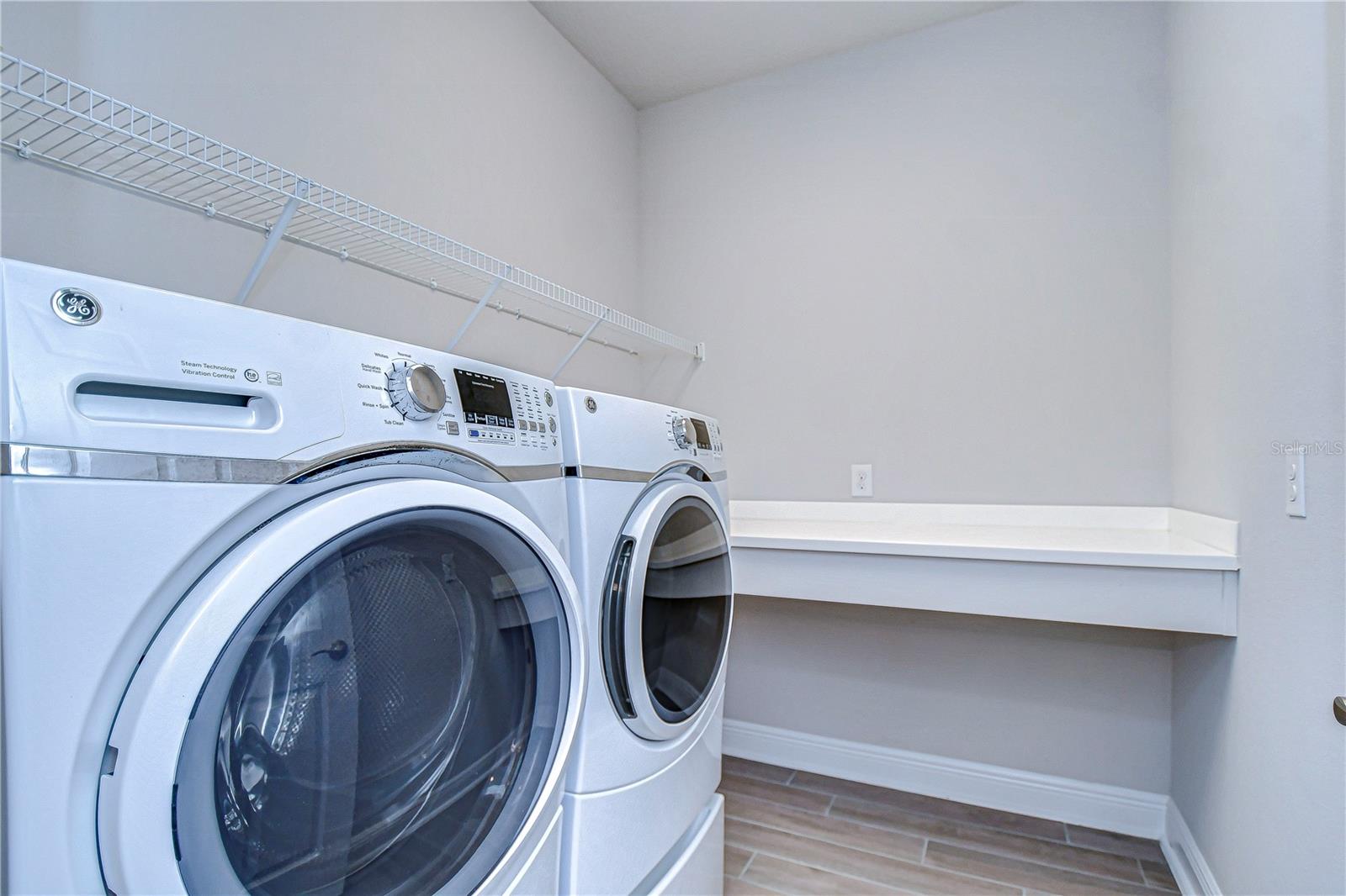 Laundry room contains storage space and a folding counter.