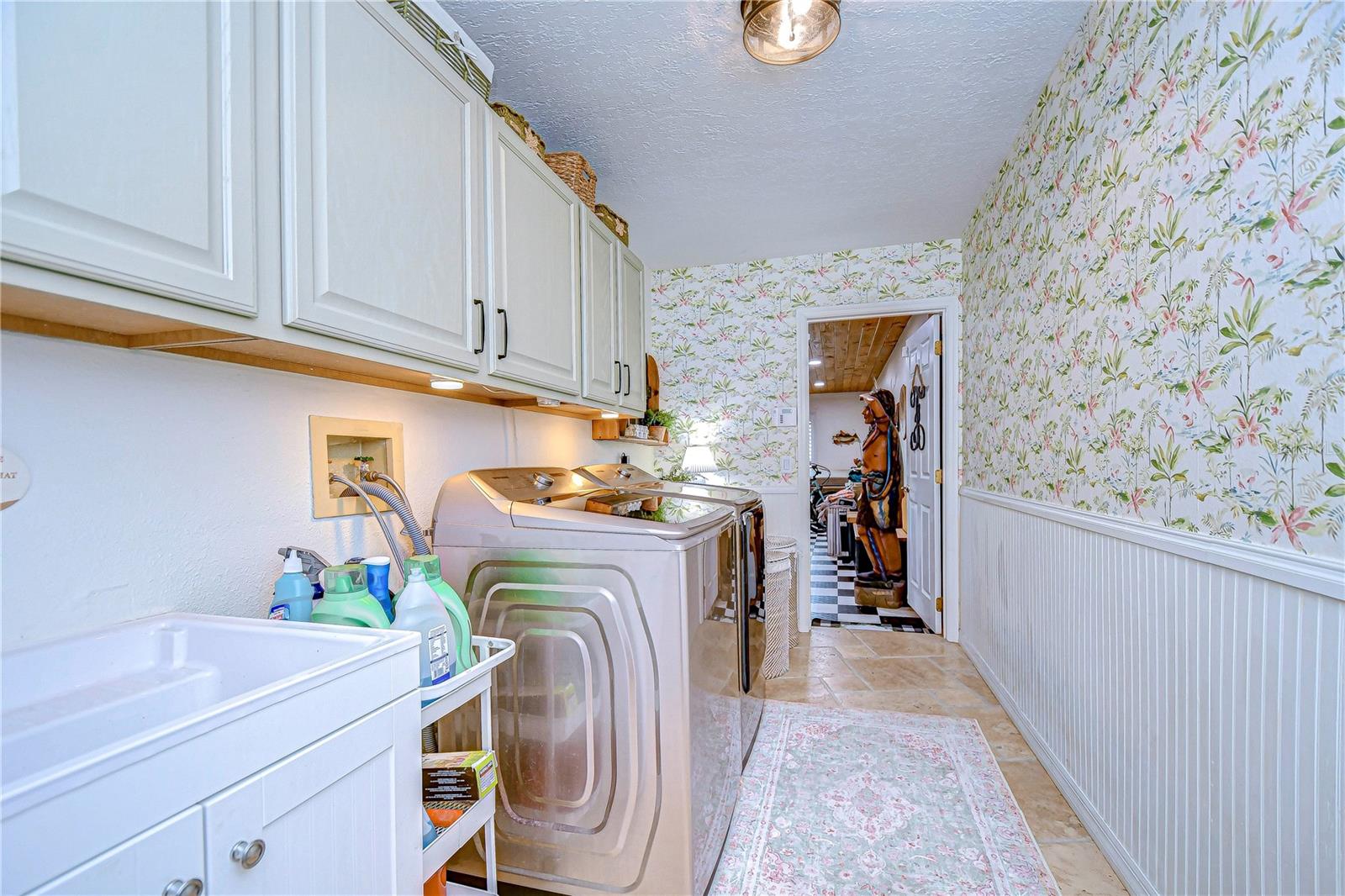 Large laundry room has a sink and plenty of cabinet space!