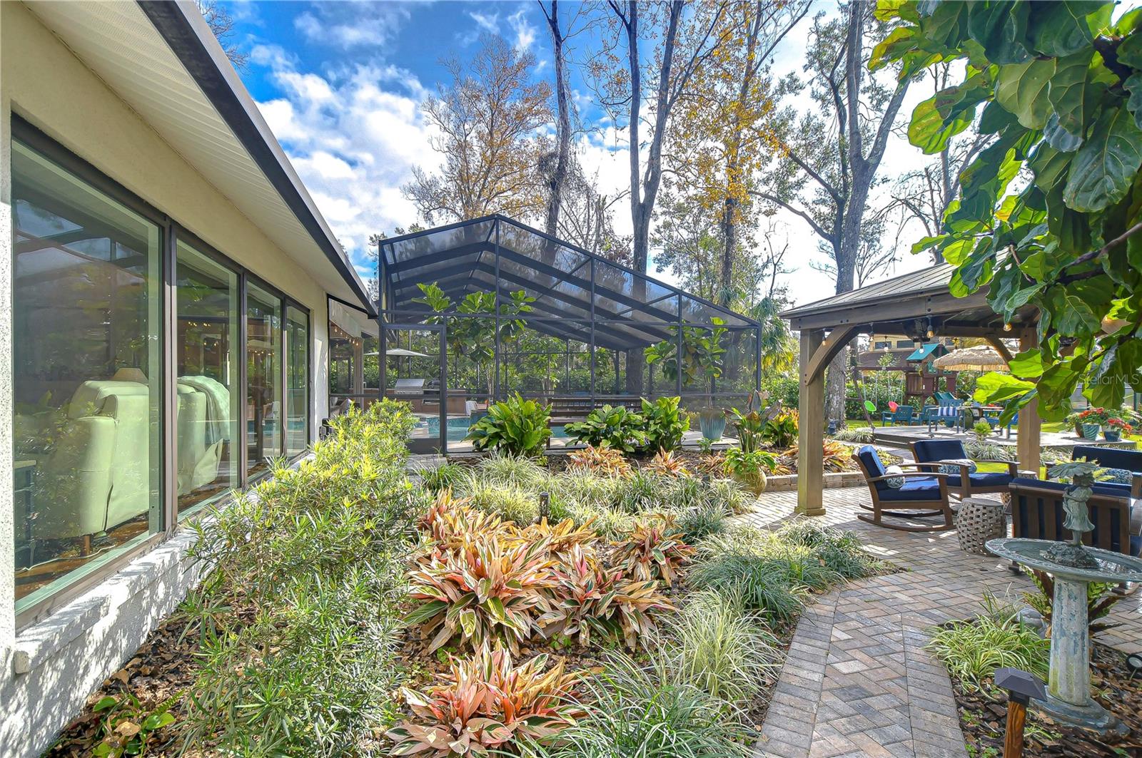 Lush landscaping and a pavered path lead to a gazebo!