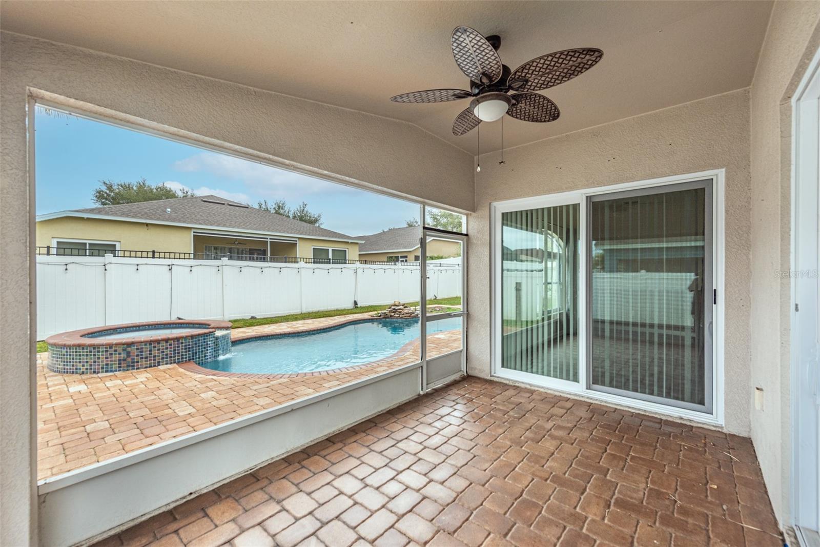 Enclosed screened porch off the Family room and primary suite overlooking the pool and hot tub with spill over feature.