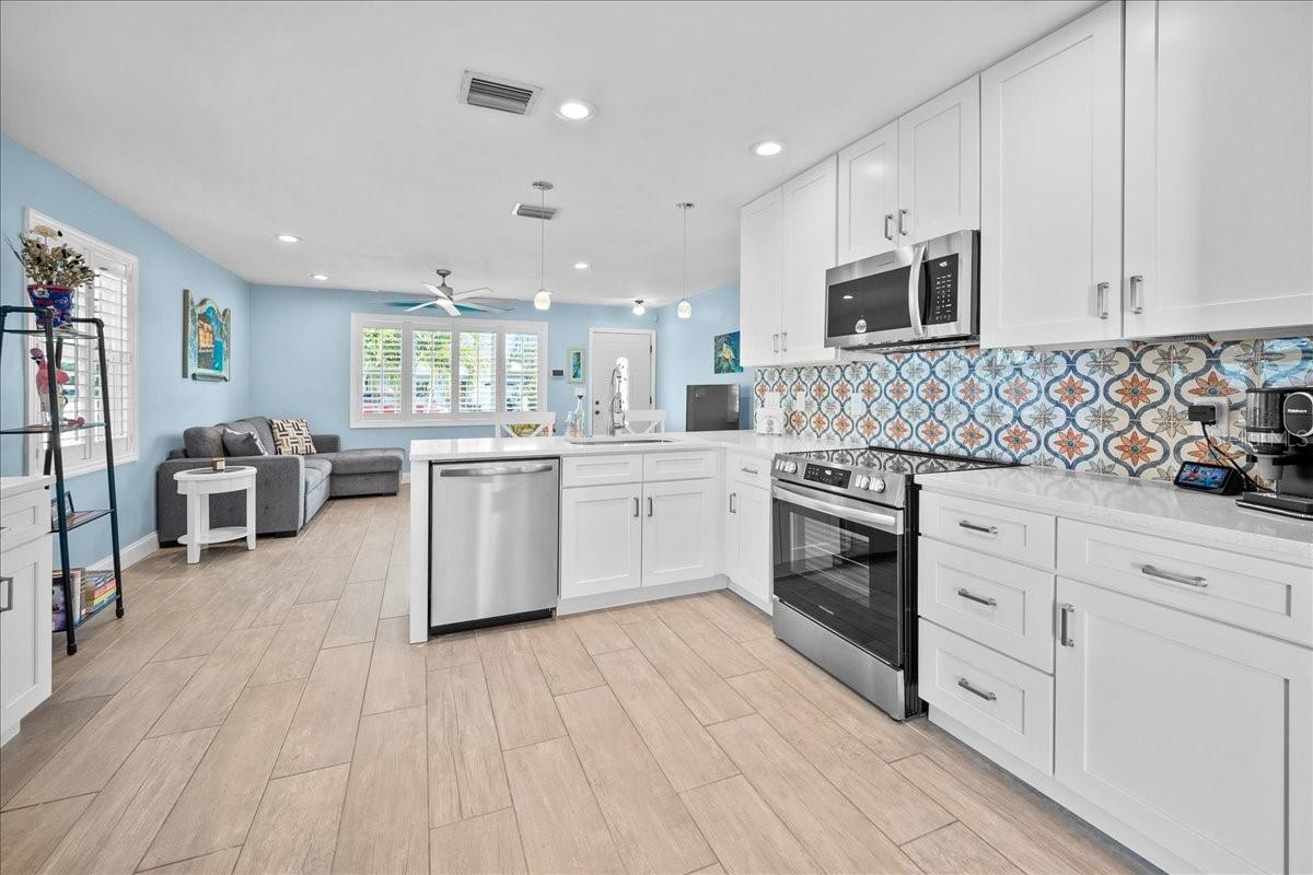 Open concept kitchen to living room with a breakfast bar is the ideal setup for entertaining or getting things done!