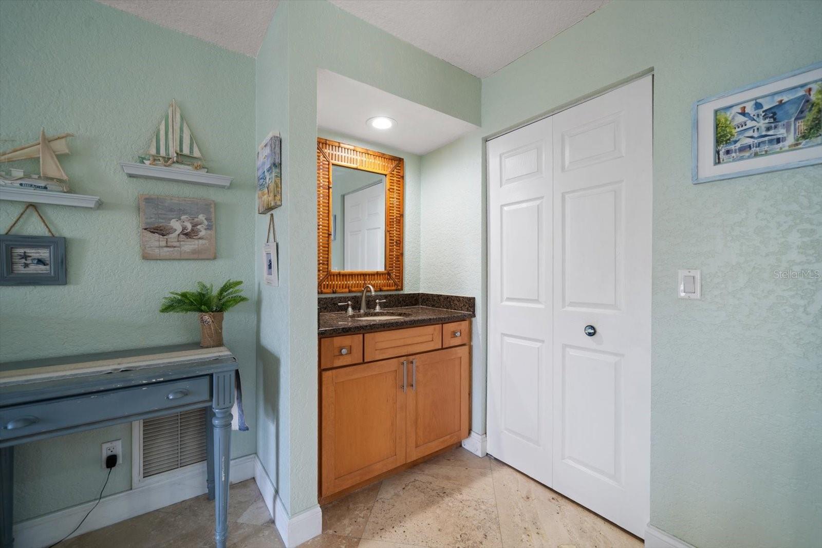 Conveniently placed vanity with sink offers added space for a his and hers dressing/grooming area.