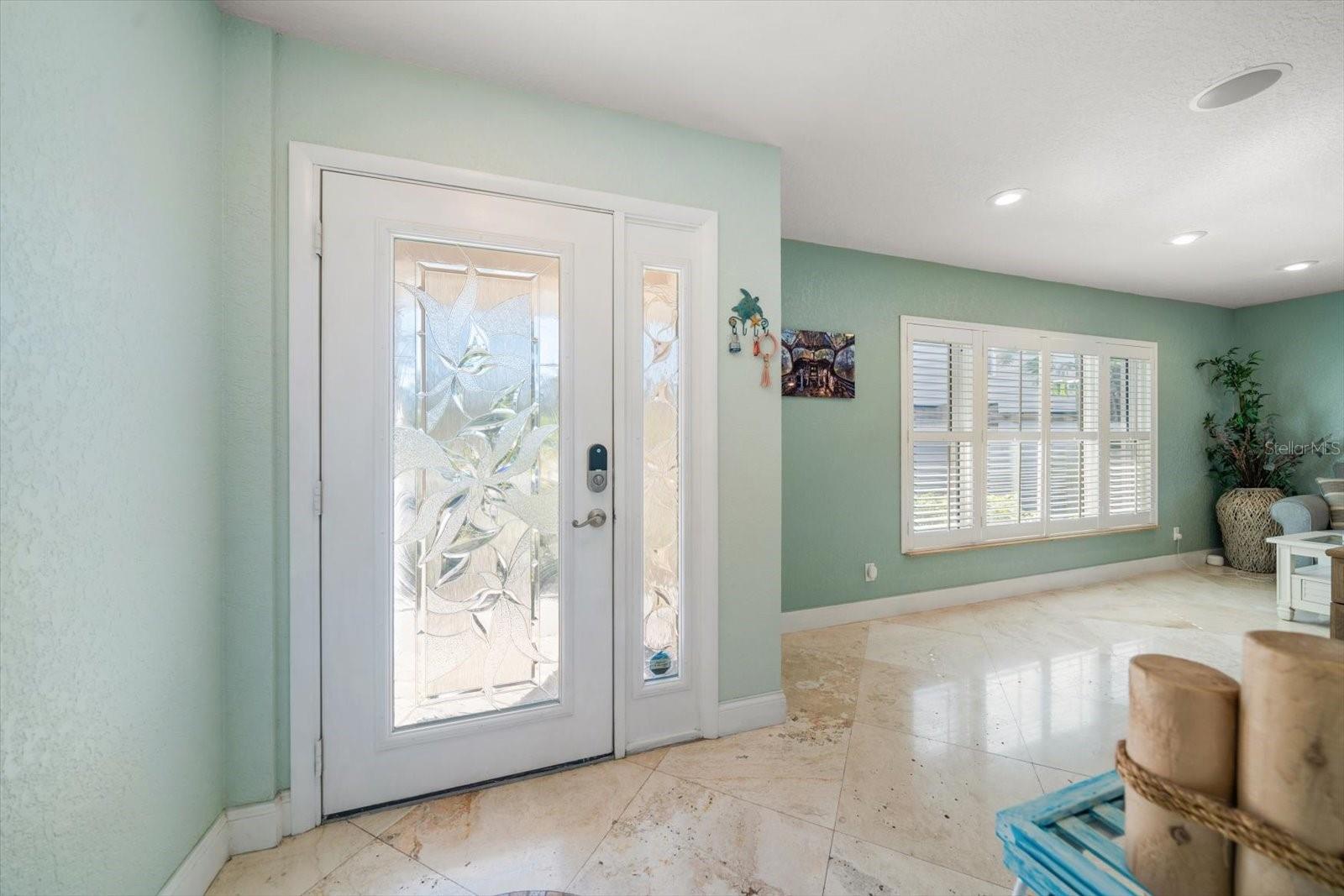 Elegant finishes are found throughout this elevated ranch home from the etched glass entryway door, to the window shutters, travertine flooring, and built-in surround sound system!