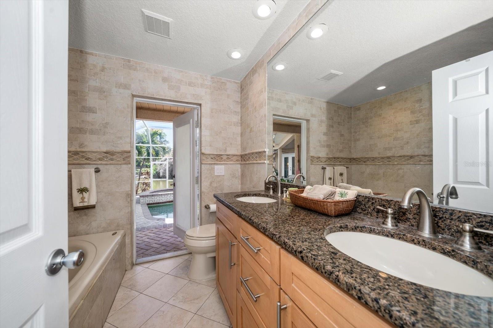 The pool bathroom serves the outdoor living areas and guest bedrooms, featuring dual vanities, jetted tub and walk-in shower!