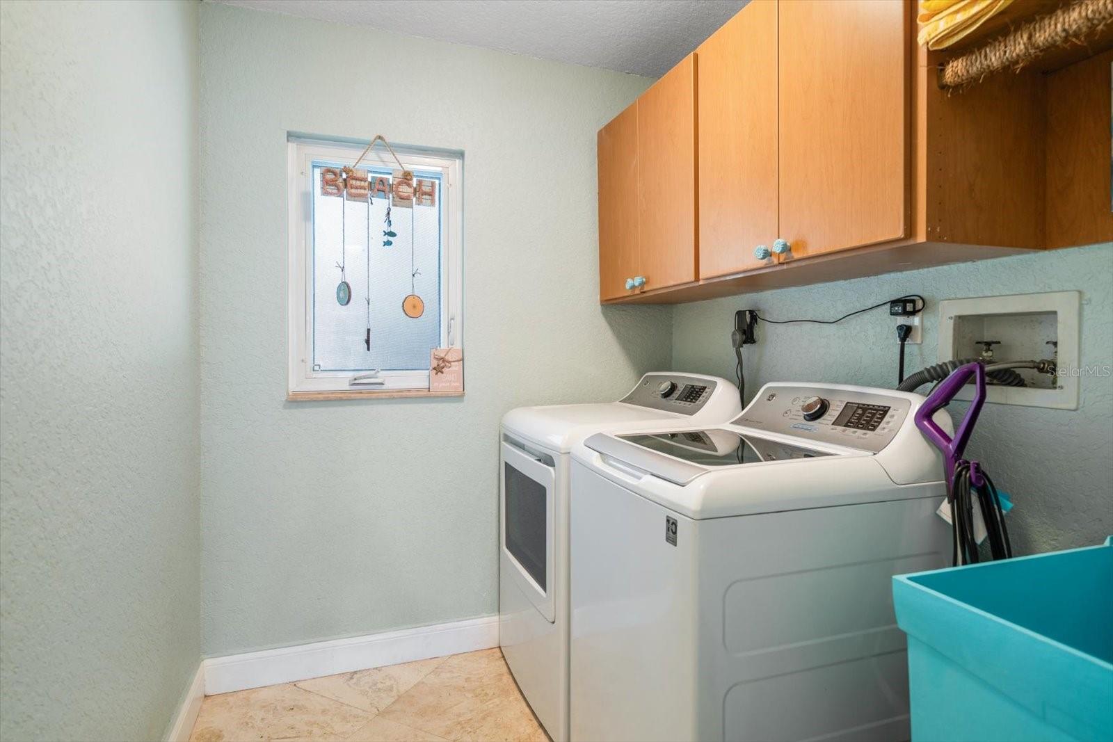 Inside utility room equipped with storage and washing basin.