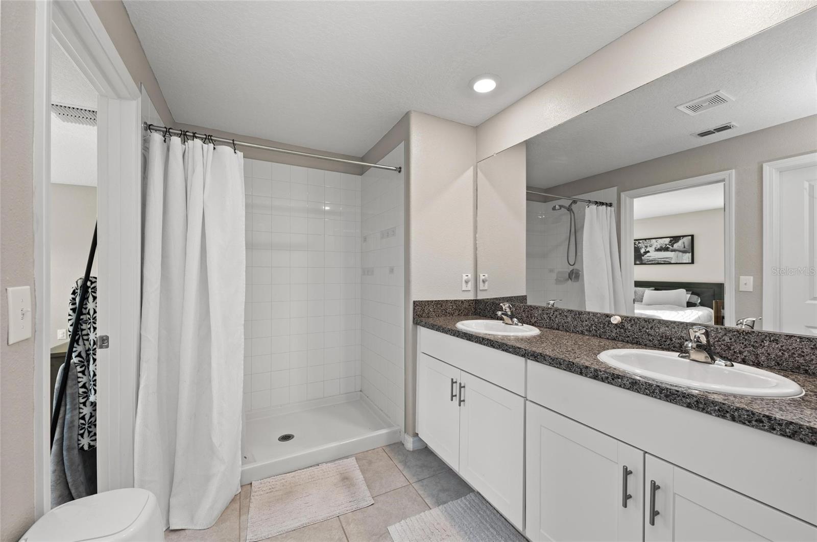 Primary bedroom ensuite bath with dual sinks and a walk-in shower.