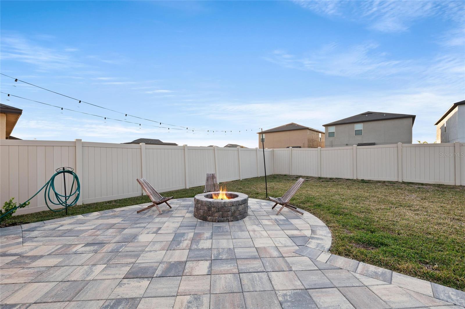 Custom built-in fire pit on paver patio.