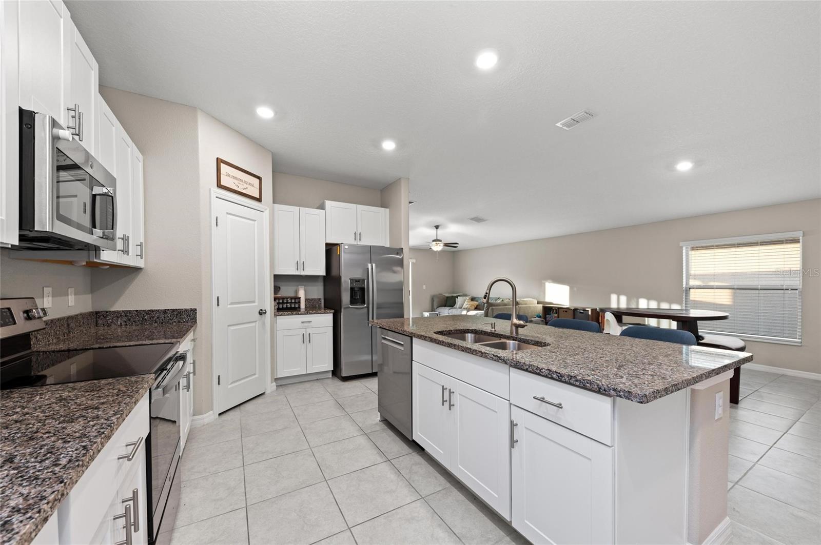 Kitchen island has barstool seating it looks out to the dining area and living room.