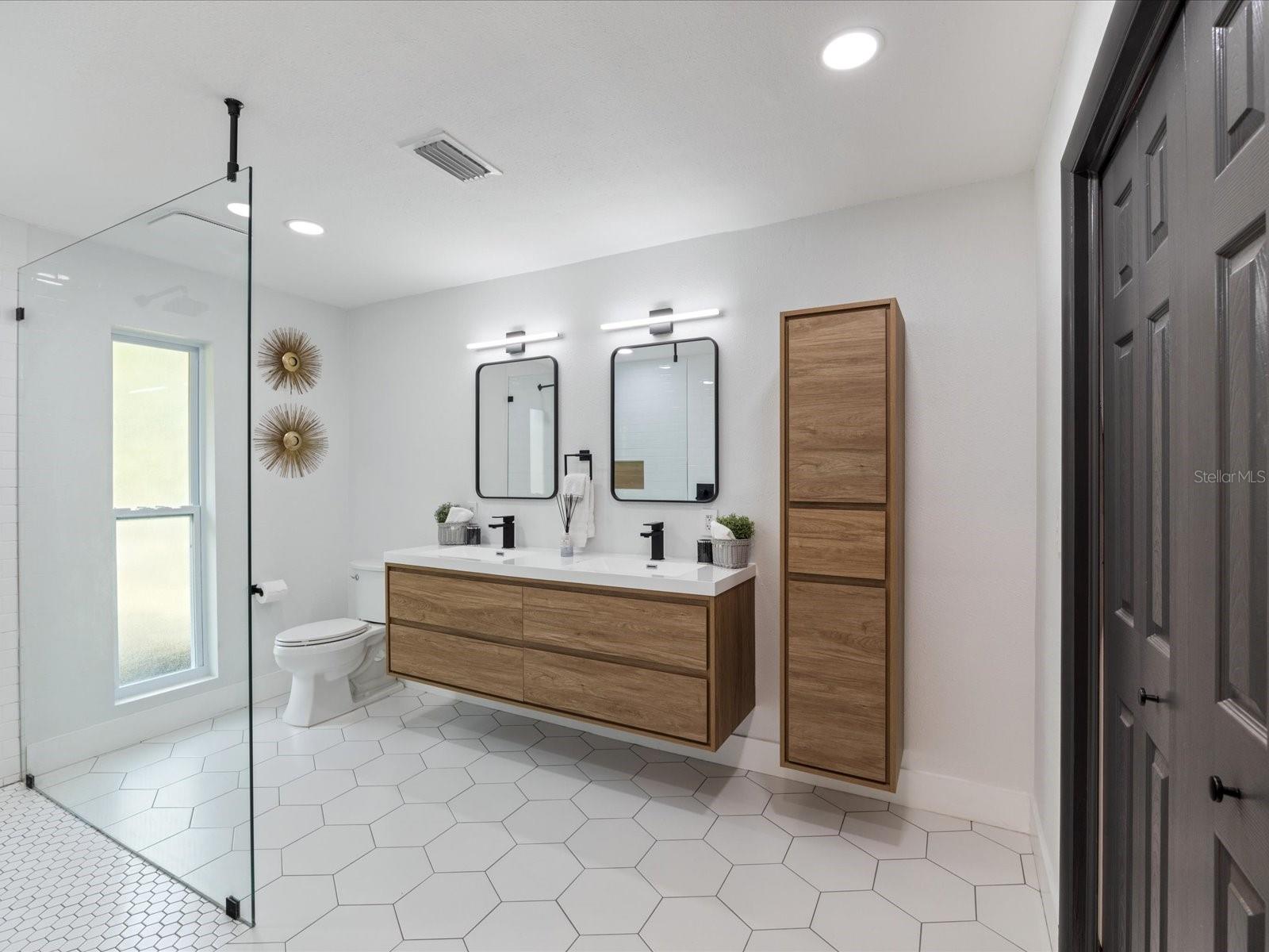 Beautifully upgraded ensuite bath with double floating vanity and walk-in closet