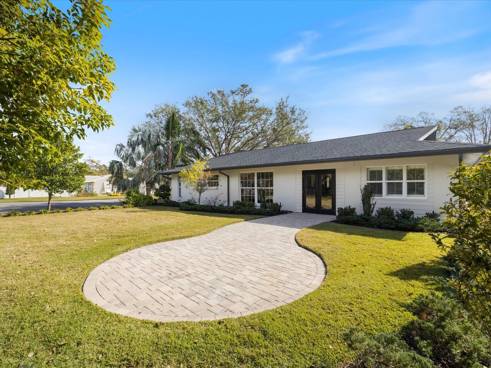 Lush green grounds with beautiful pavers, perfect set-up for a fire pit