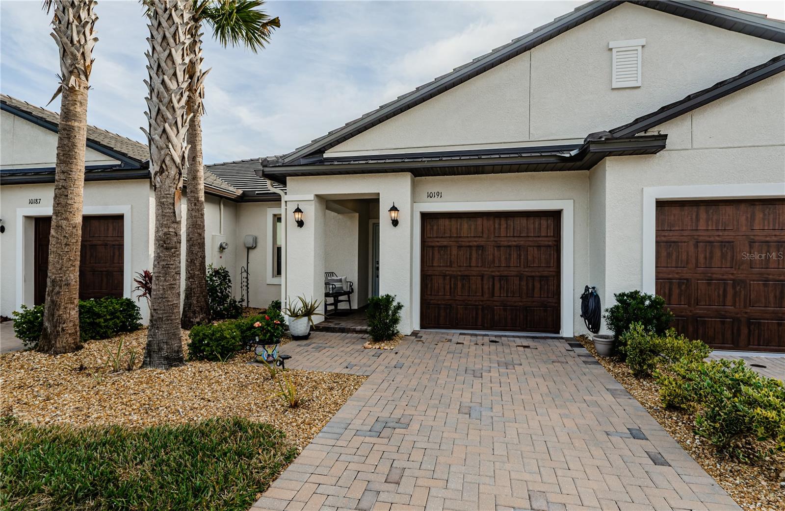 From the moment you arrive, you’ll be captivated by the paver driveway, elegant coach lighting, and lush landscaping with mature palm trees, creating an inviting and serene entryway. The covered front porch is the perfect spot to enjoy your morning coffee. This home also features exterior gutters for easy maintenance and a stylish wood-finished garage door that adds to its modern yet warm aesthetic. Step inside and experience the comfort and elegance this home has to offer!