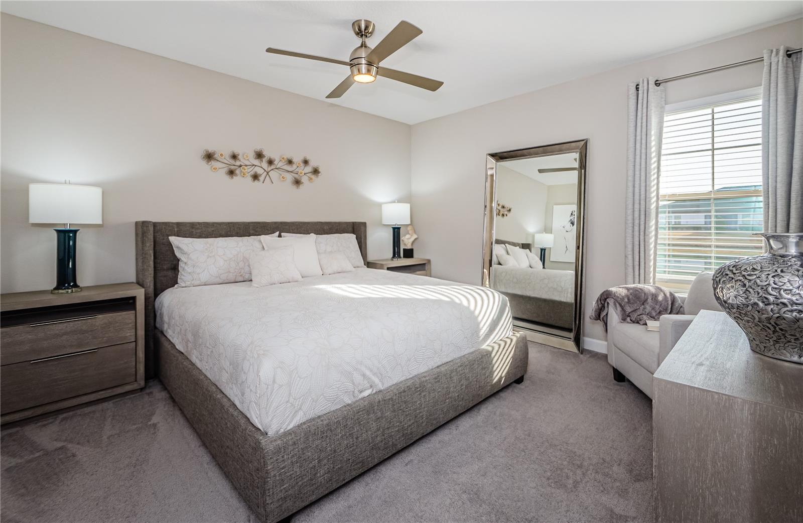 Unwind in this serene primary suite, designed for rest and relaxation. The plush carpeting, soft neutral tones, and expansive windows create a bright yet cozy atmosphere.  The ensuite bath add to the convenience, making this your perfect private retreat within the home.