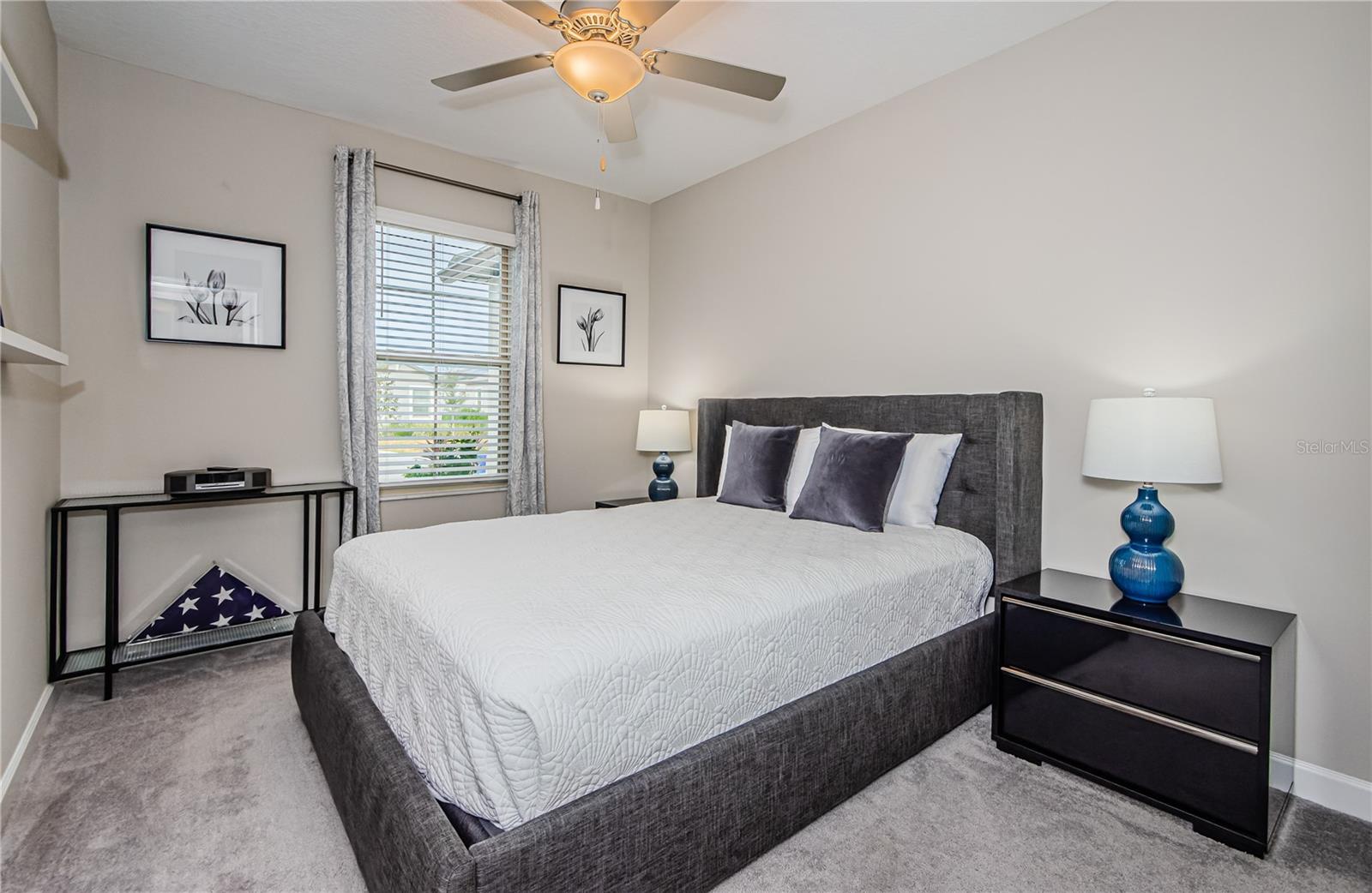 The secondary bedroom has natural light pours in through the large window, creating an airy feel, and the ceiling fan ensures year-round comfort. This versatile space is perfect for guests or as a private home office—tailored to fit your lifestyle