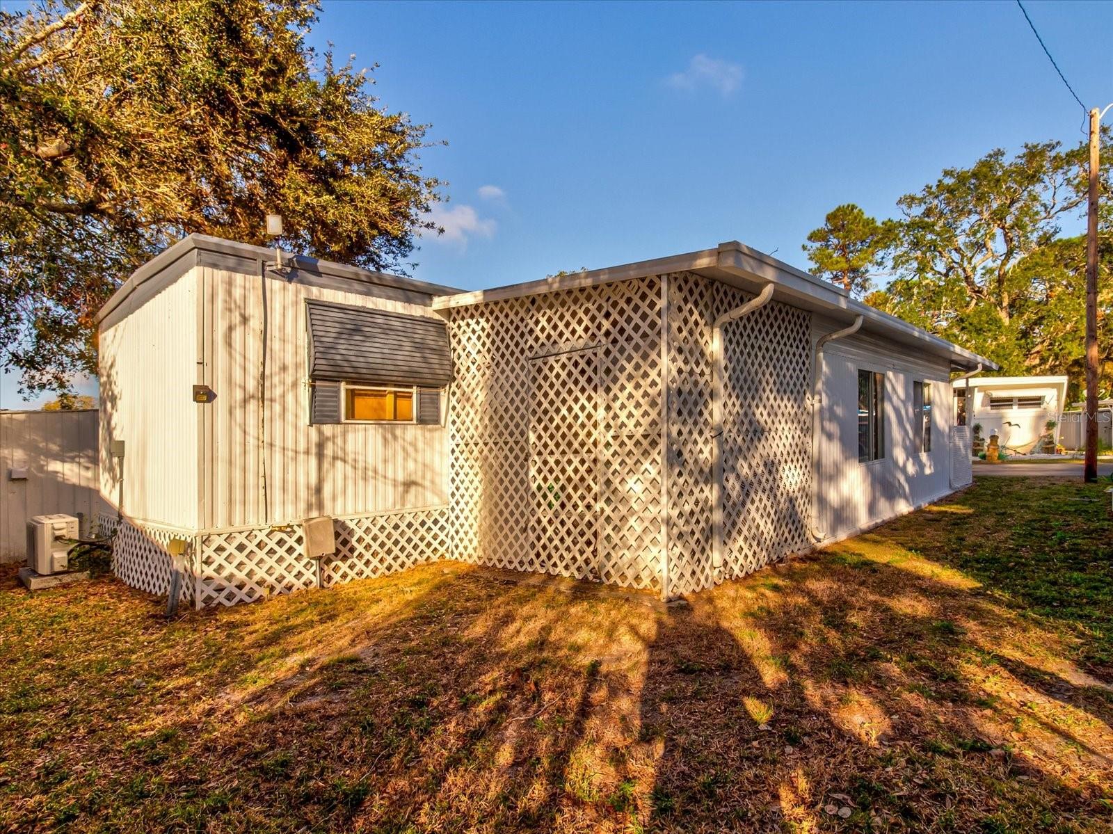 North Side of Home Shows Parking For Three Vehicles and Laundry Shed