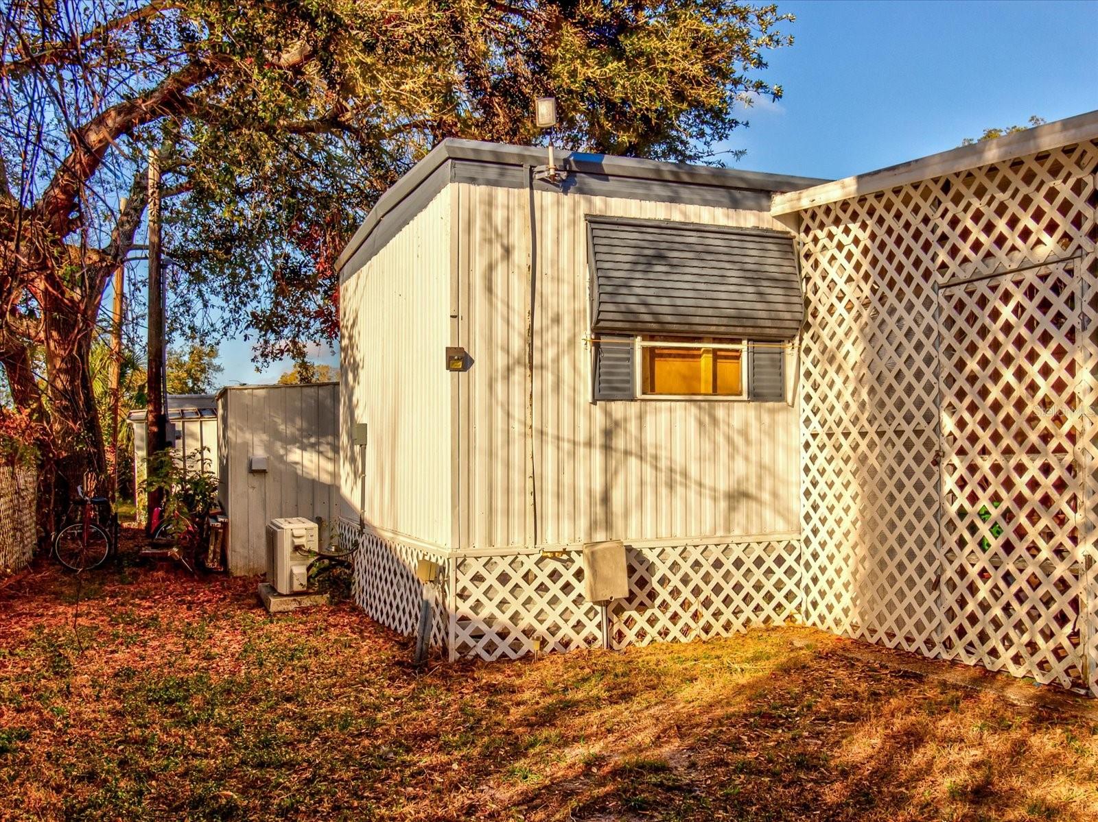 Northwest Side of Home Showing Parking for Three Vehicles, Grilling Area, Side Door Entrance, and Street