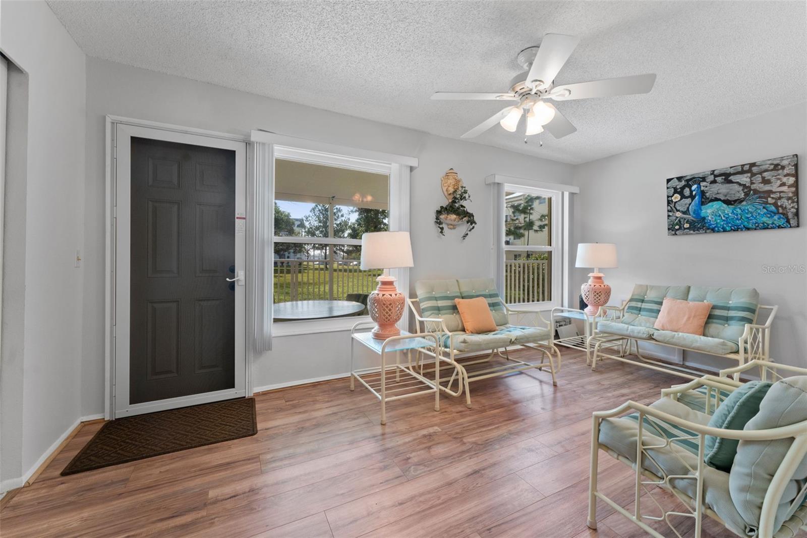 Florida room has a screened door to encourage a breeze through the unit and energy efficient hurricane impact windows throughout unit.