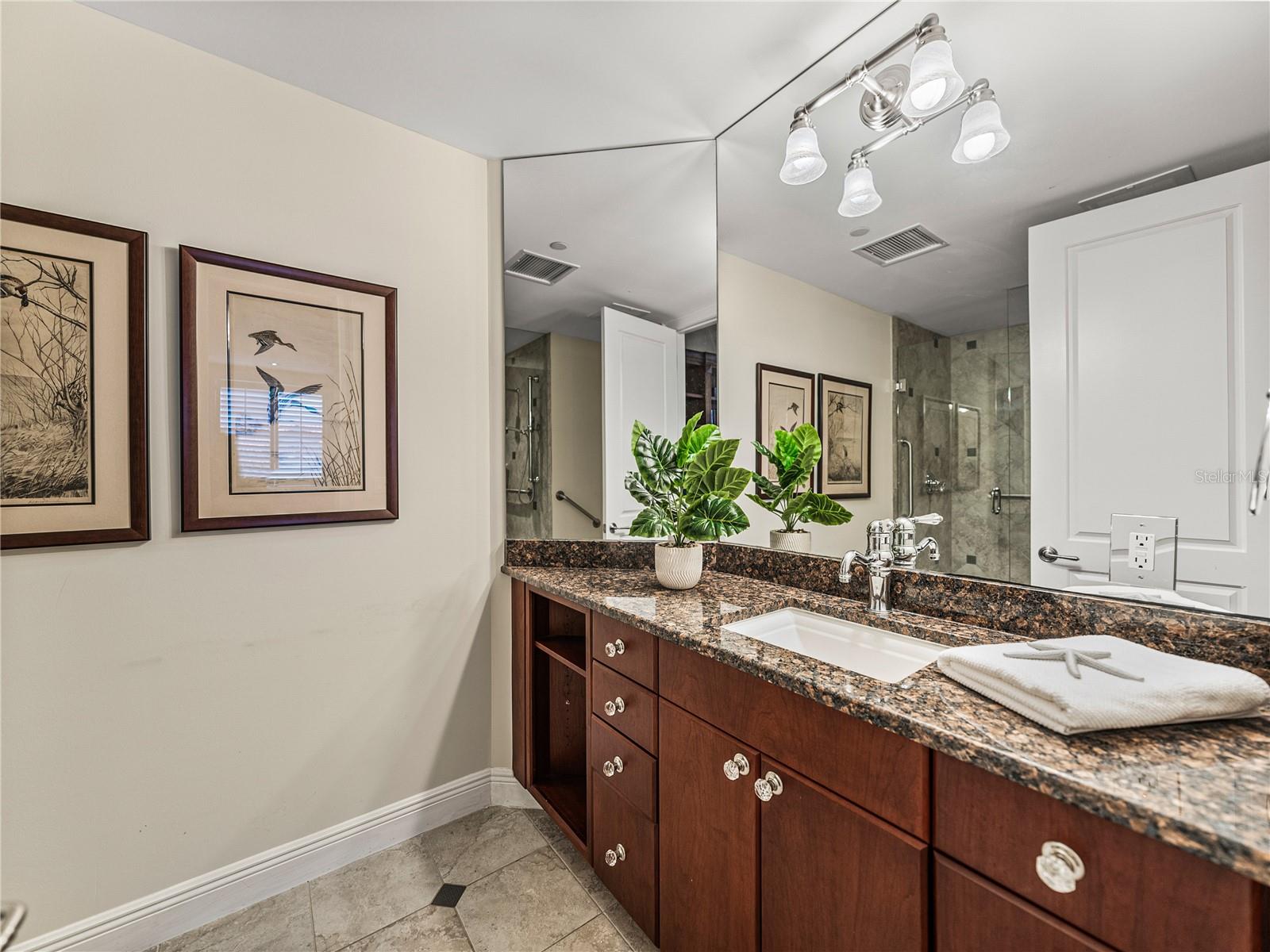 The ensuite bathroom has all-wood cabinetry and granite countertops.