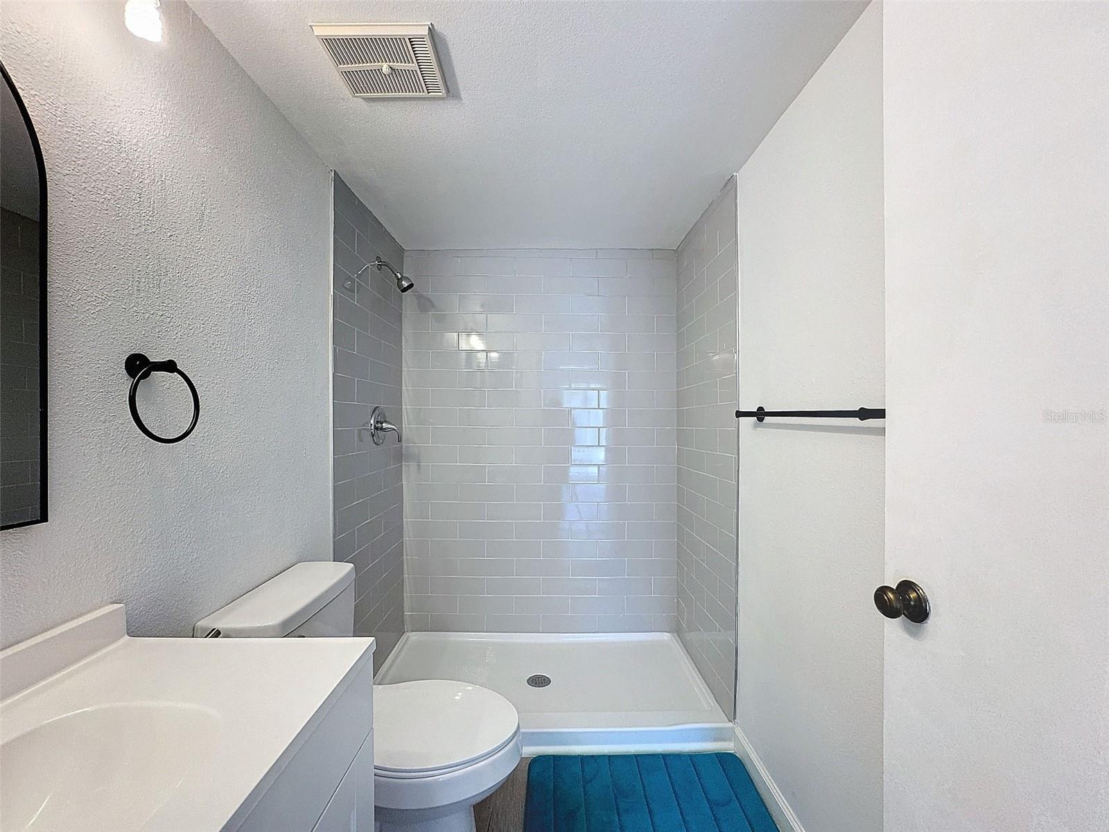 New shower, vanity, floor, and toilet