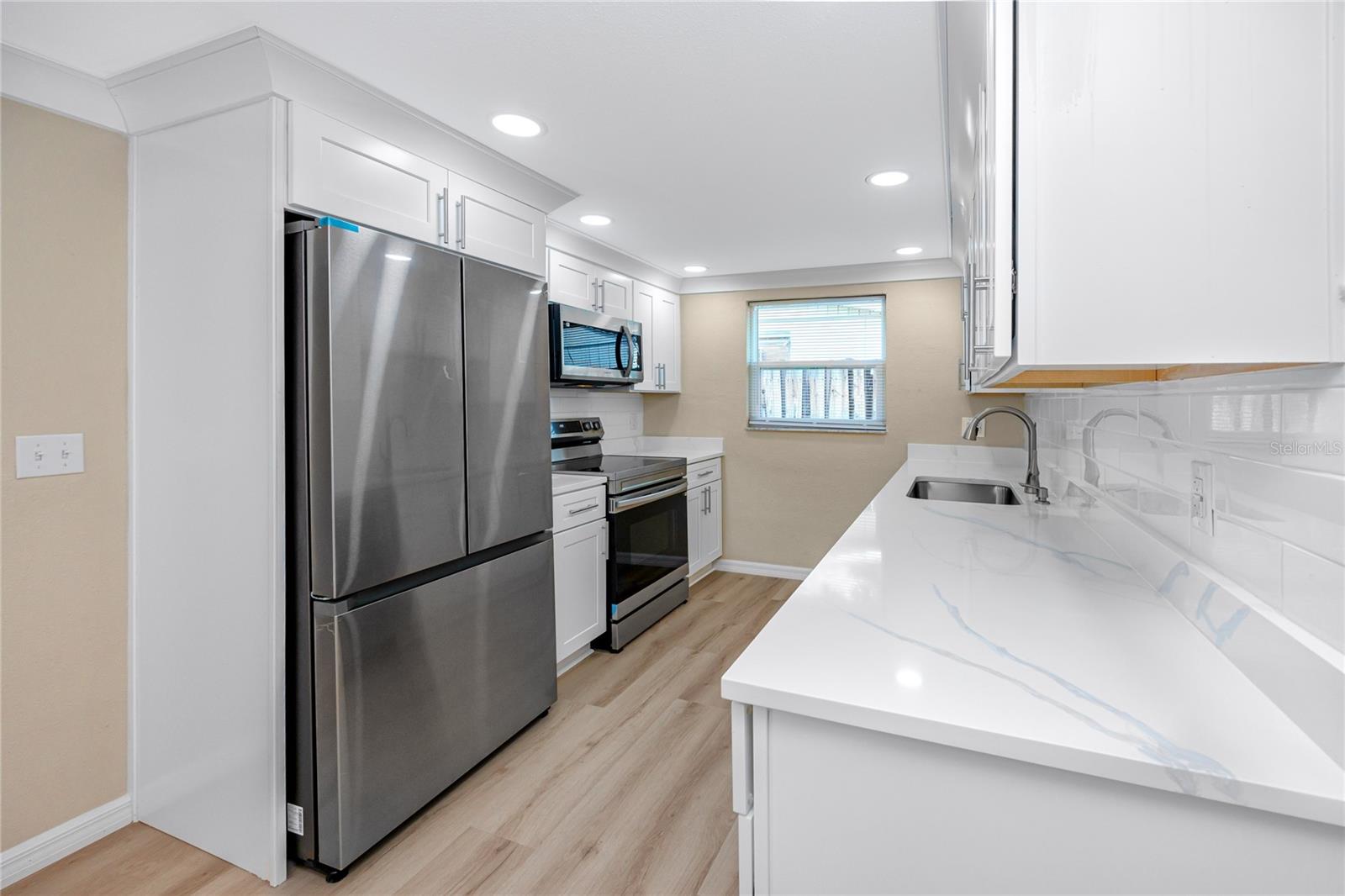 Kitchen with granite counters, shaker cabinets and NEW stainless steel appliances.