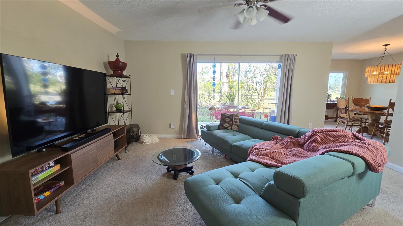 Large living room with plenty of natural lighting. with a view of the Golf Course in the rear.