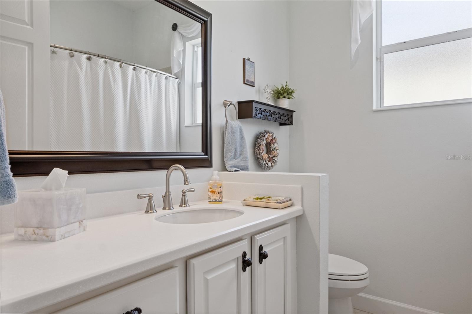 Guest bath with tub and shower combo and frosted window for privacy