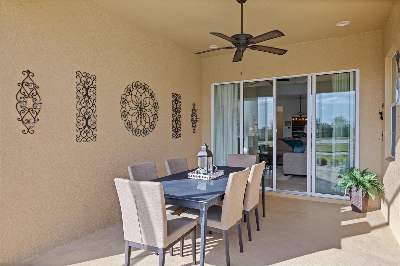 Impact sliding doors open to L-Shaped screened lanai overlooking the 7th hole of the golf course