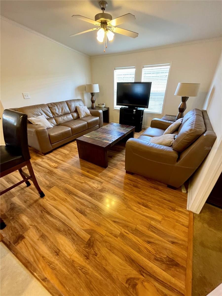 Family room with laminate flooring, leather furniture