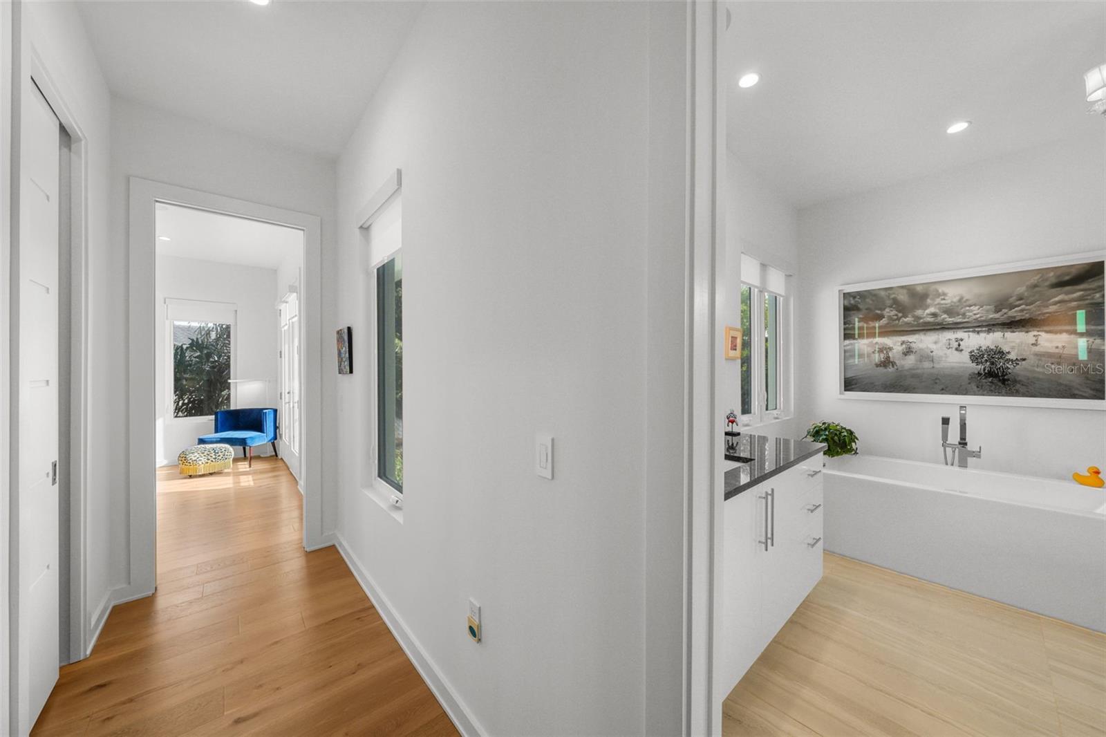 The hallway between the primary bedroom and ensuite bathroom has two large walk-in closets with custom closet systems