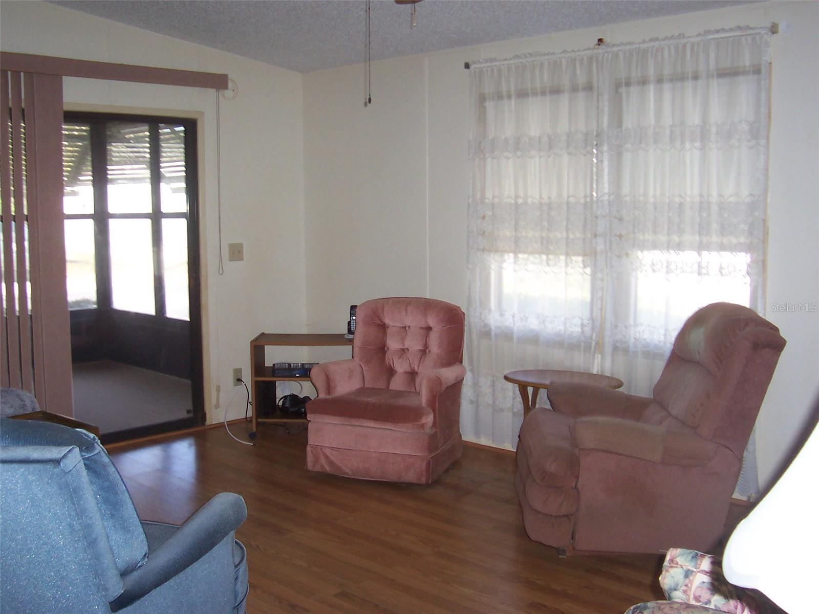 Living Room has direct access to the front glassed in front porch through the sliding glass doors.