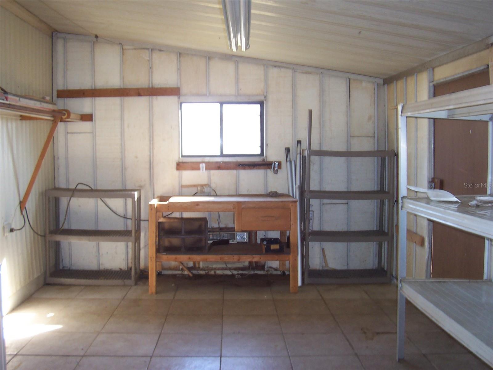 Check out this tiled floor workshop/laundry area!!  Nice work bench with window providing natural light.