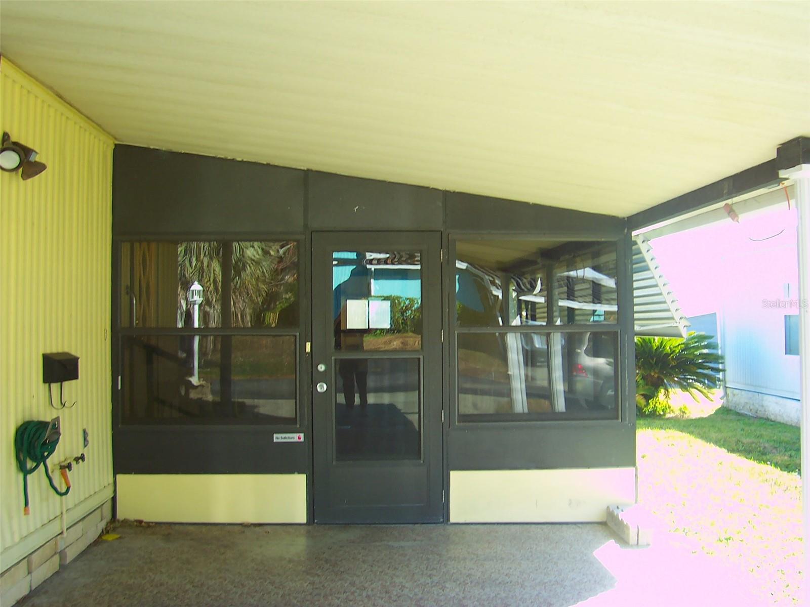 Carport entry into the 17x11 glassed in side porch.